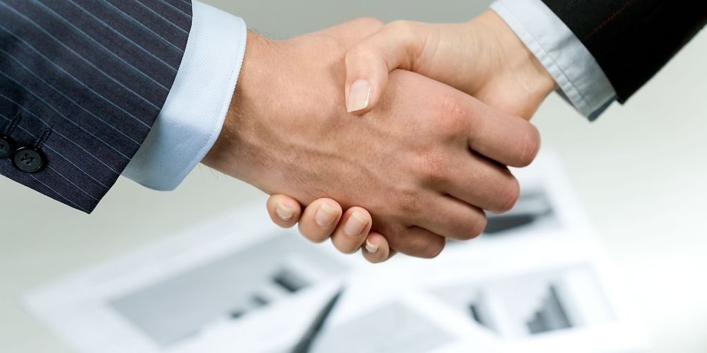 real estate agent shaking hands with client in front of a house in Laguna Beach