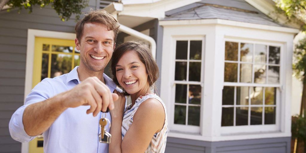 real estate agent shaking hands with client in front of a house in Fountain Valley