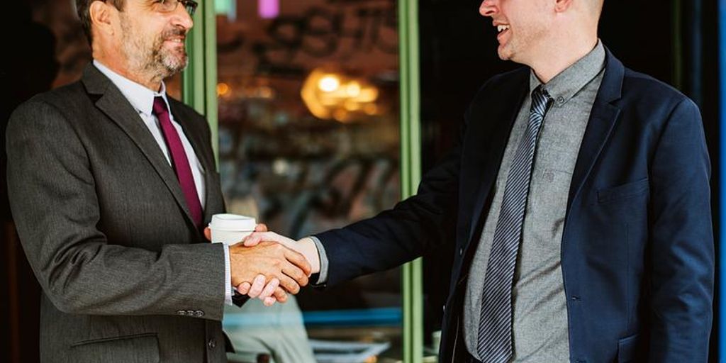 real estate agent shaking hands with client in front of house in West Covina