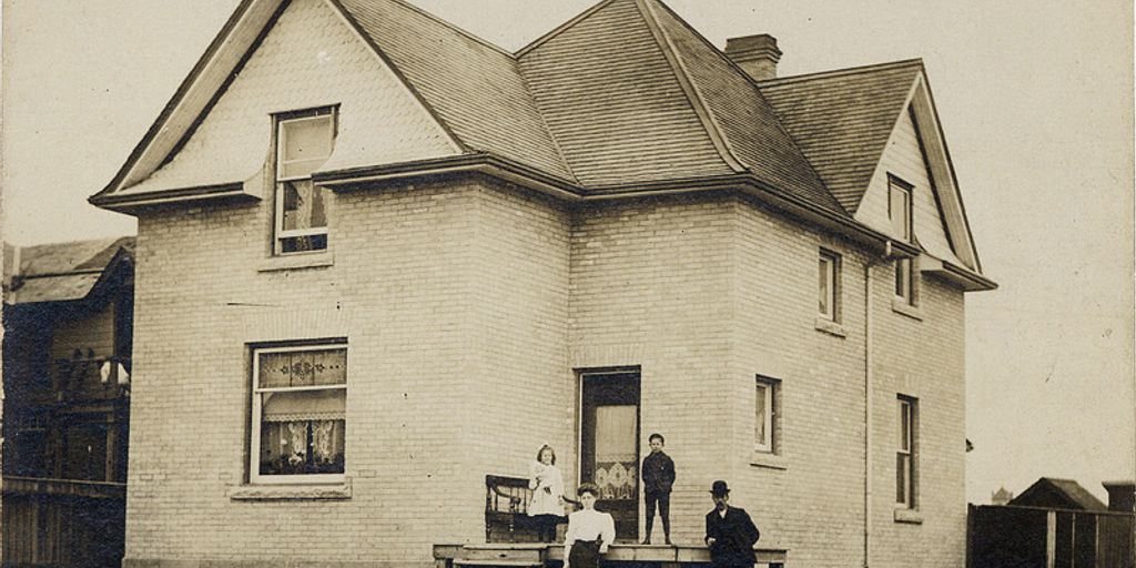 happy family in front of sold house in Norco