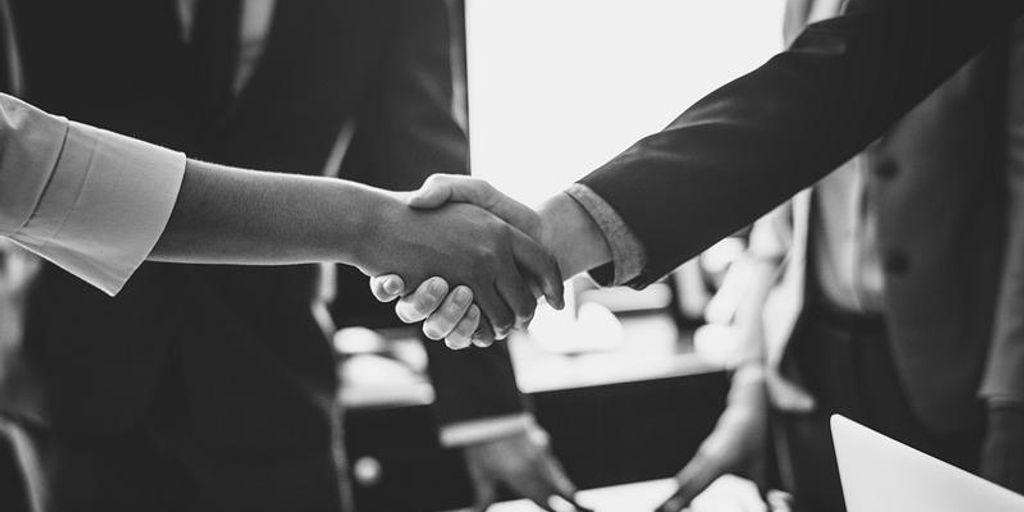 real estate agent shaking hands with client in front of house in San Luis Obispo