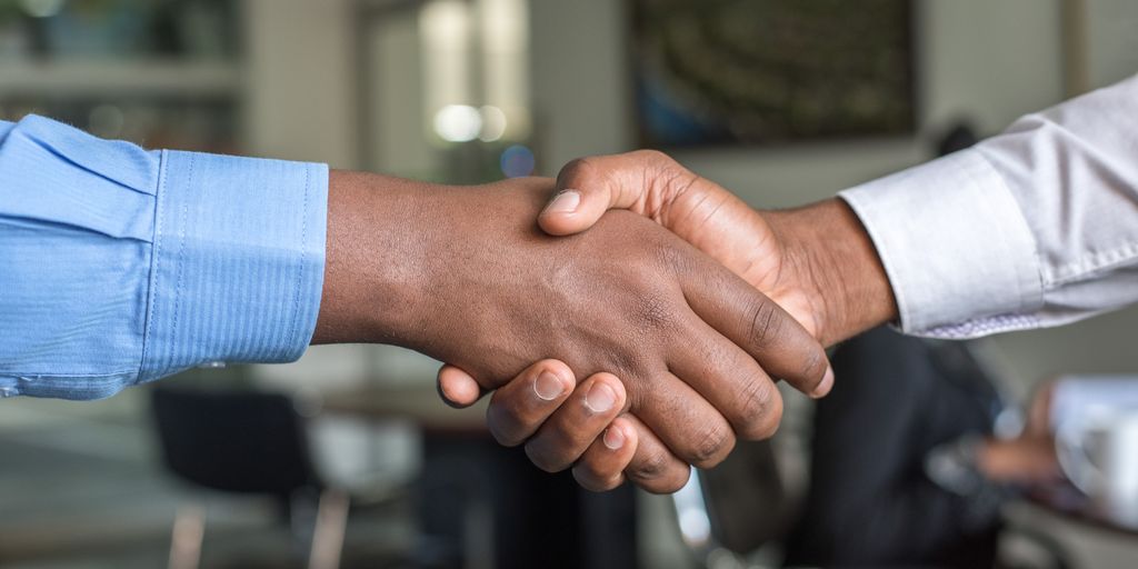 real estate agent shaking hands with client in front of house in Imperial Beach