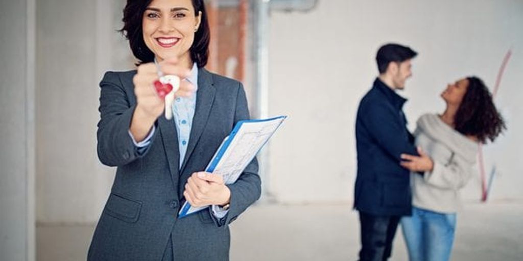 real estate agent handing keys to new homeowners in front of a house in Burbank