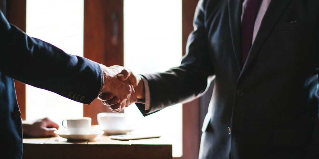 real estate agent shaking hands with client in front of a house in West Hollywood