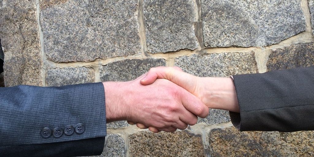 real estate agent shaking hands with client in front of house in City of Industry