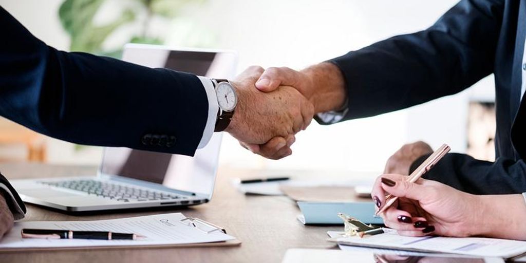 real estate agent shaking hands with client in front of house in Santa Maria