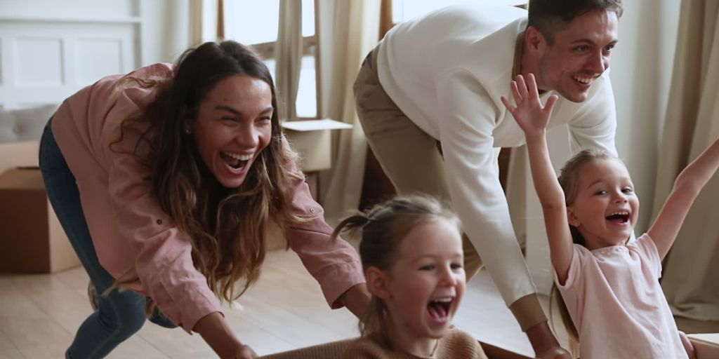 happy family holding sold sign outside suburban house