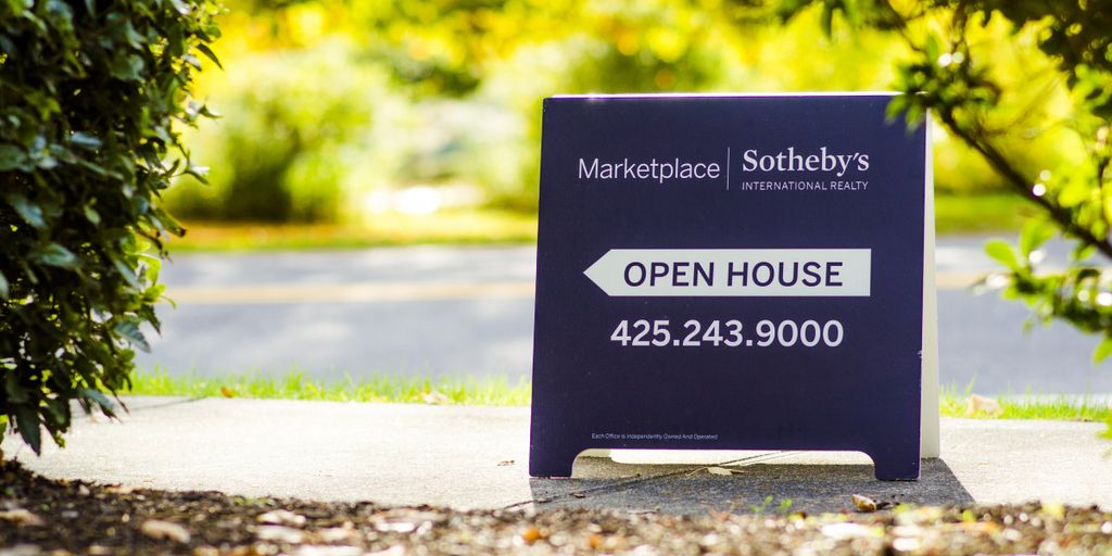 real estate agent showing house to happy family in suburban neighborhood