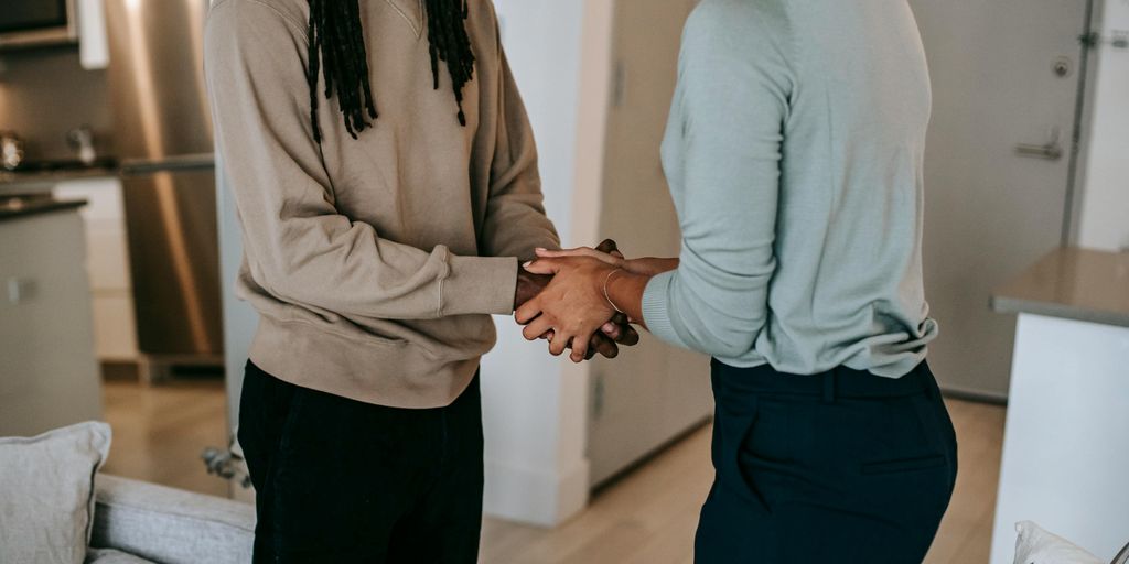 real estate agent shaking hands with client in front of house in Los Alamitos